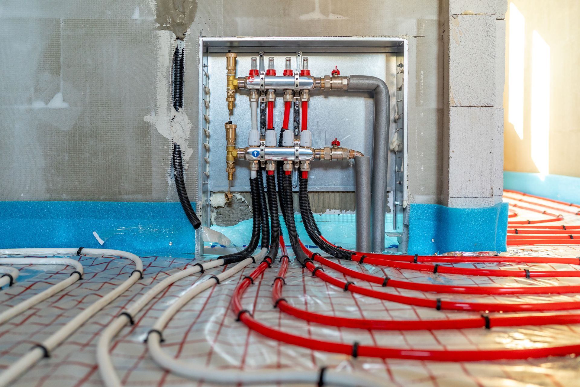 A bunch of pipes are connected to a wall in a room.
