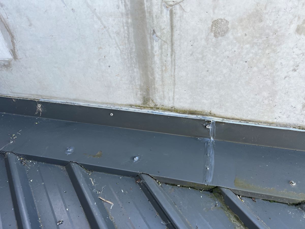 A Close Up of a Metal Roof With a Concrete Wall in the Background — Fig Facility Services in Lara, VIC