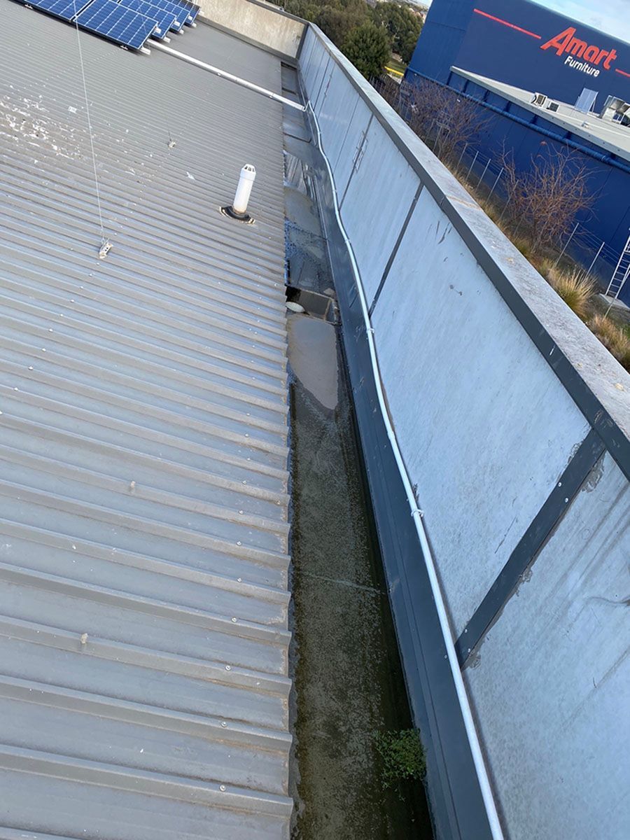 The Roof of a Building With a Blue Building in the Background — Fig Facility Services in Grovedale, VIC