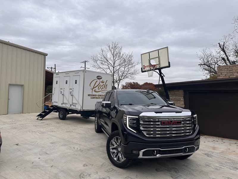 Black truck towing a white trailer with 