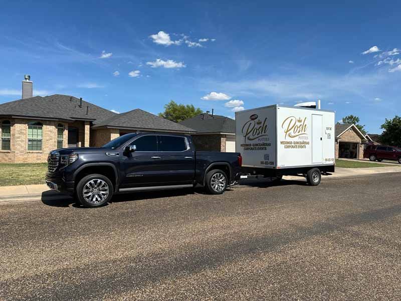 Dark pickup truck towing a white trailer with the word 
