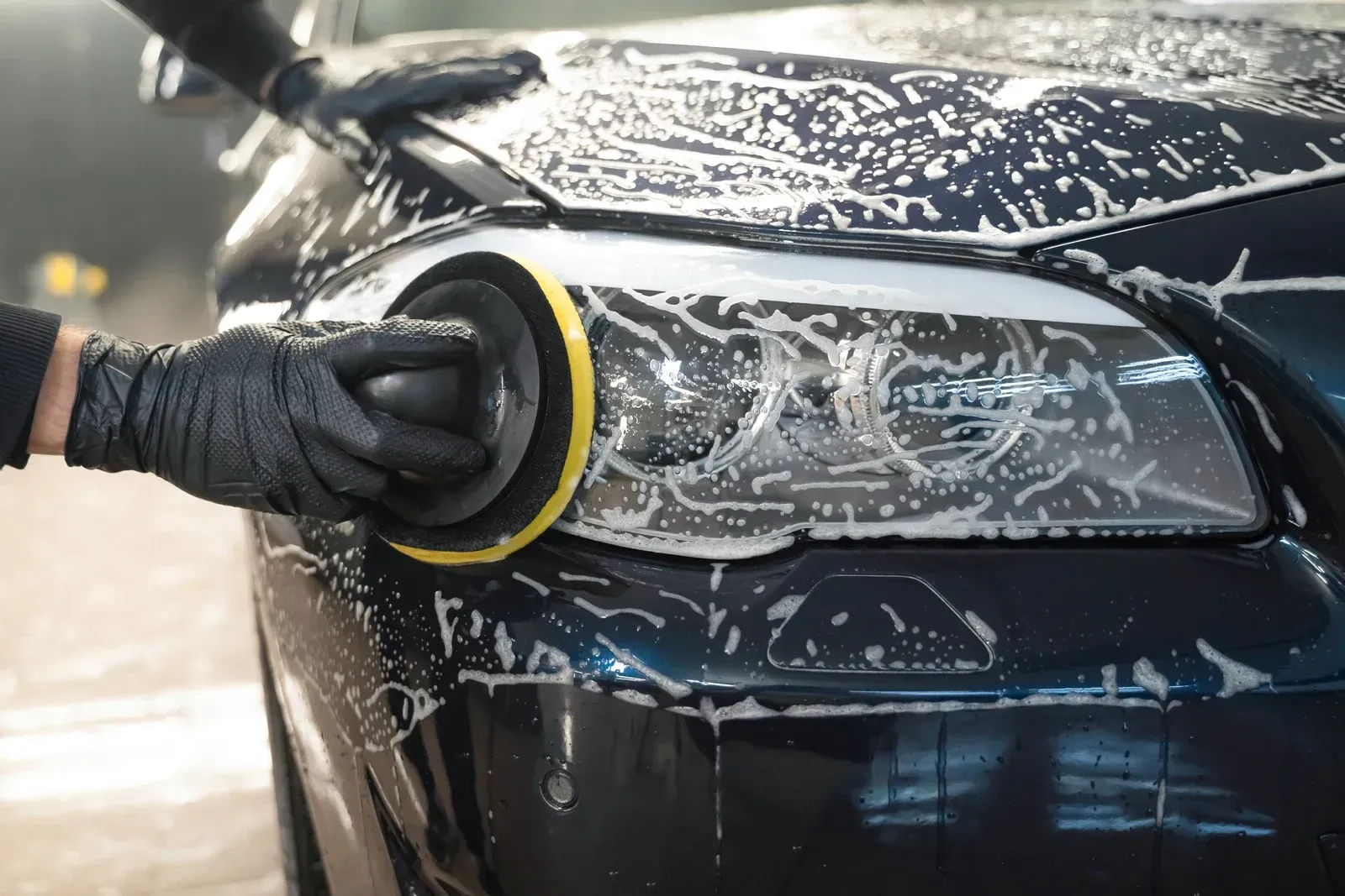 A car covered in foam is parked in a parking lot