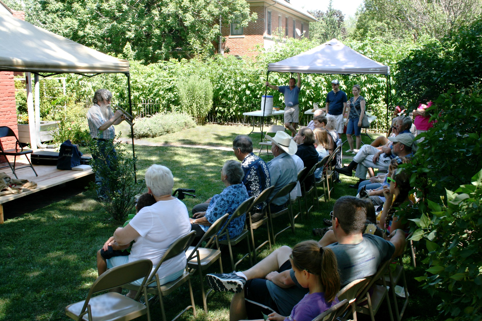 A group of people are sitting in chairs under a tent