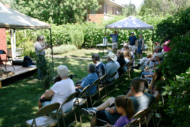 A group of people are sitting in chairs under a tent