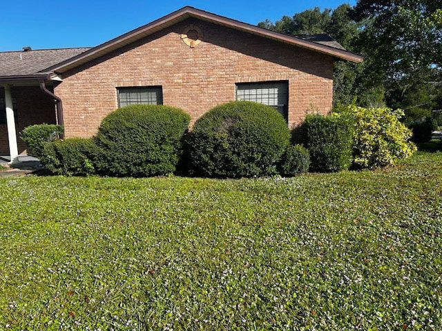 A brick house with bushes in front of it