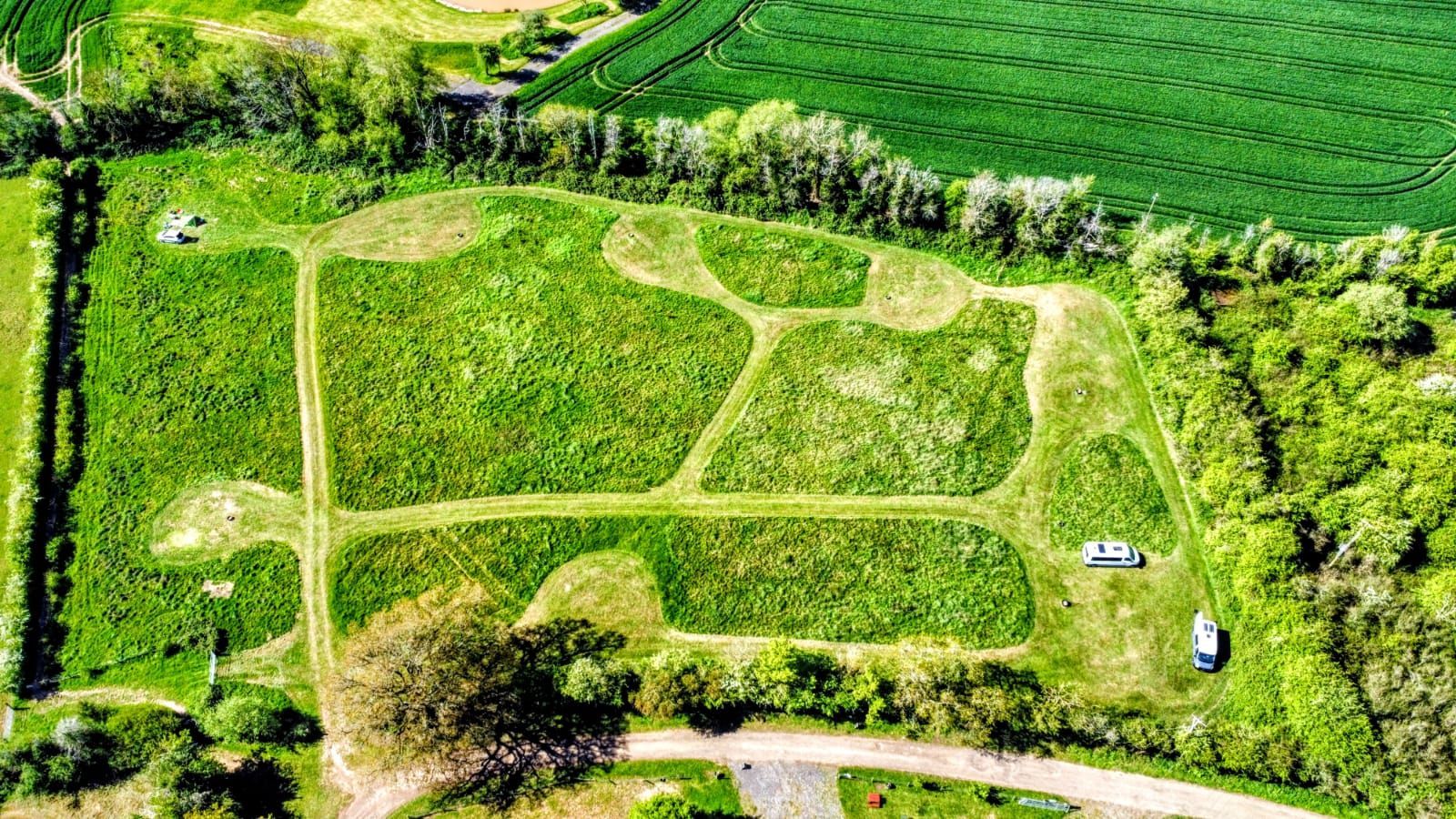 Aerial view of The Apple Farm's 3-acre camping meadow in Snitterfield, showing the extra-large mown pitches available for exclusive-use group camping in Warwickshire