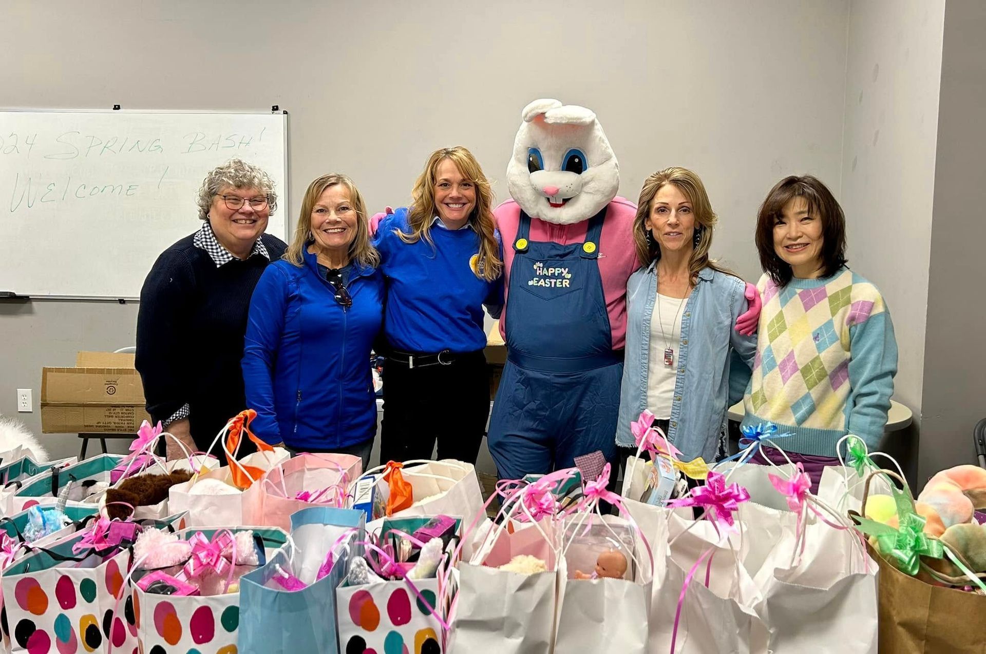 People with Easter Bunny pose with gift bags.