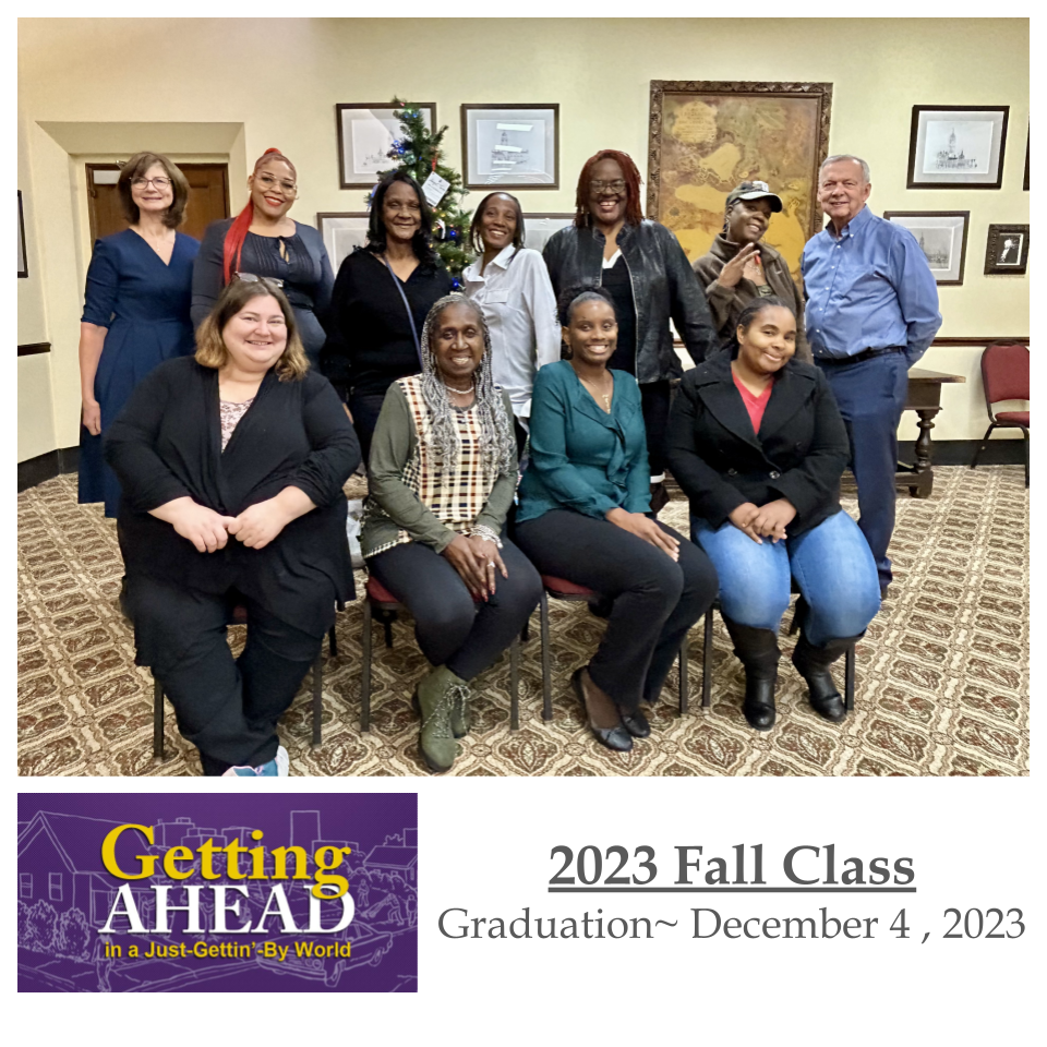 2023 Fall Graduation class photo. Ten people, diverse group, smiling in a room with framed pictures.