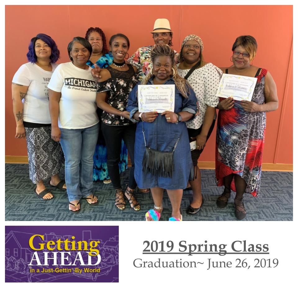 Group of people at a graduation, holding certificates;