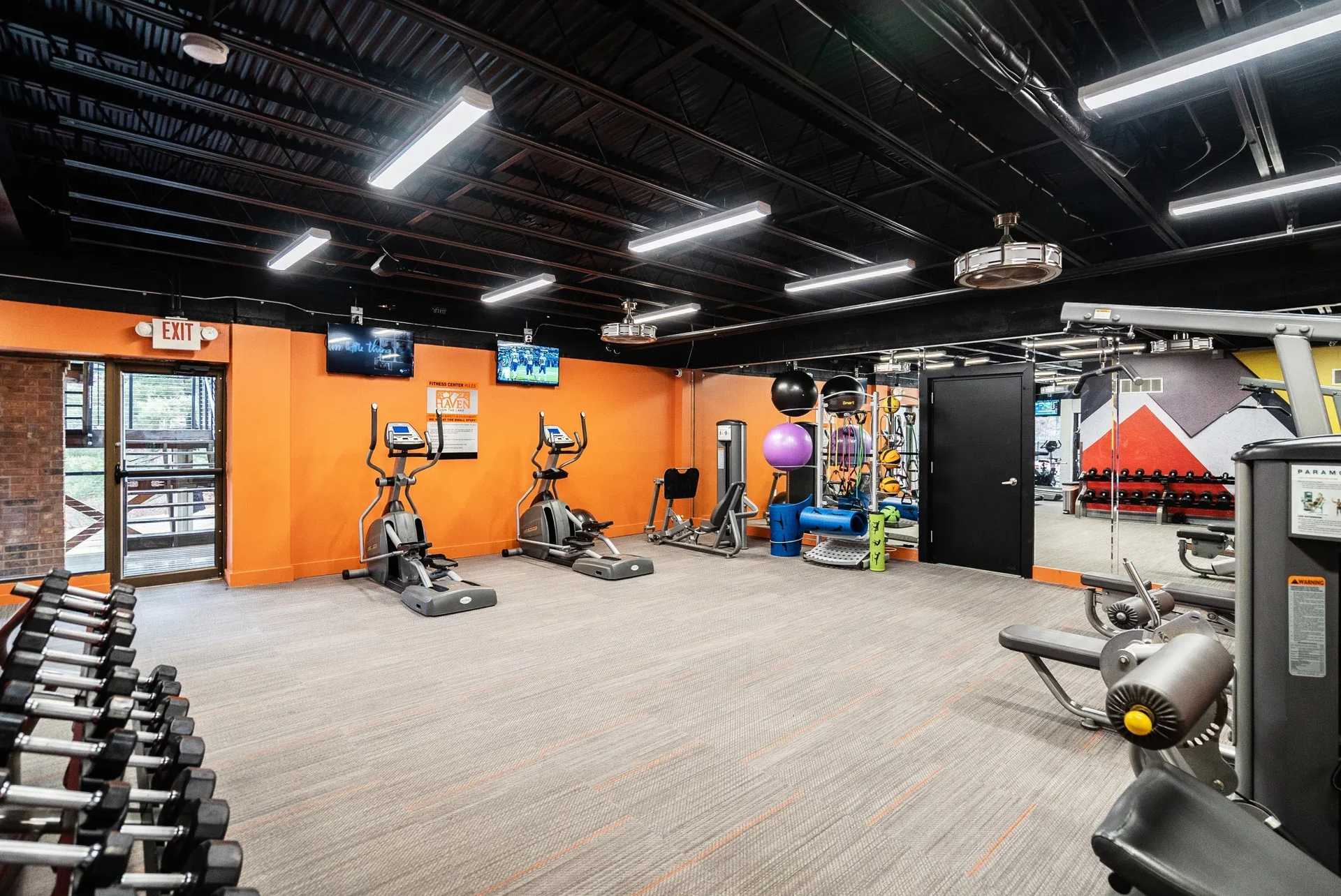 Indoor fitness center with cardio machines, free weights, and exercise equipment.