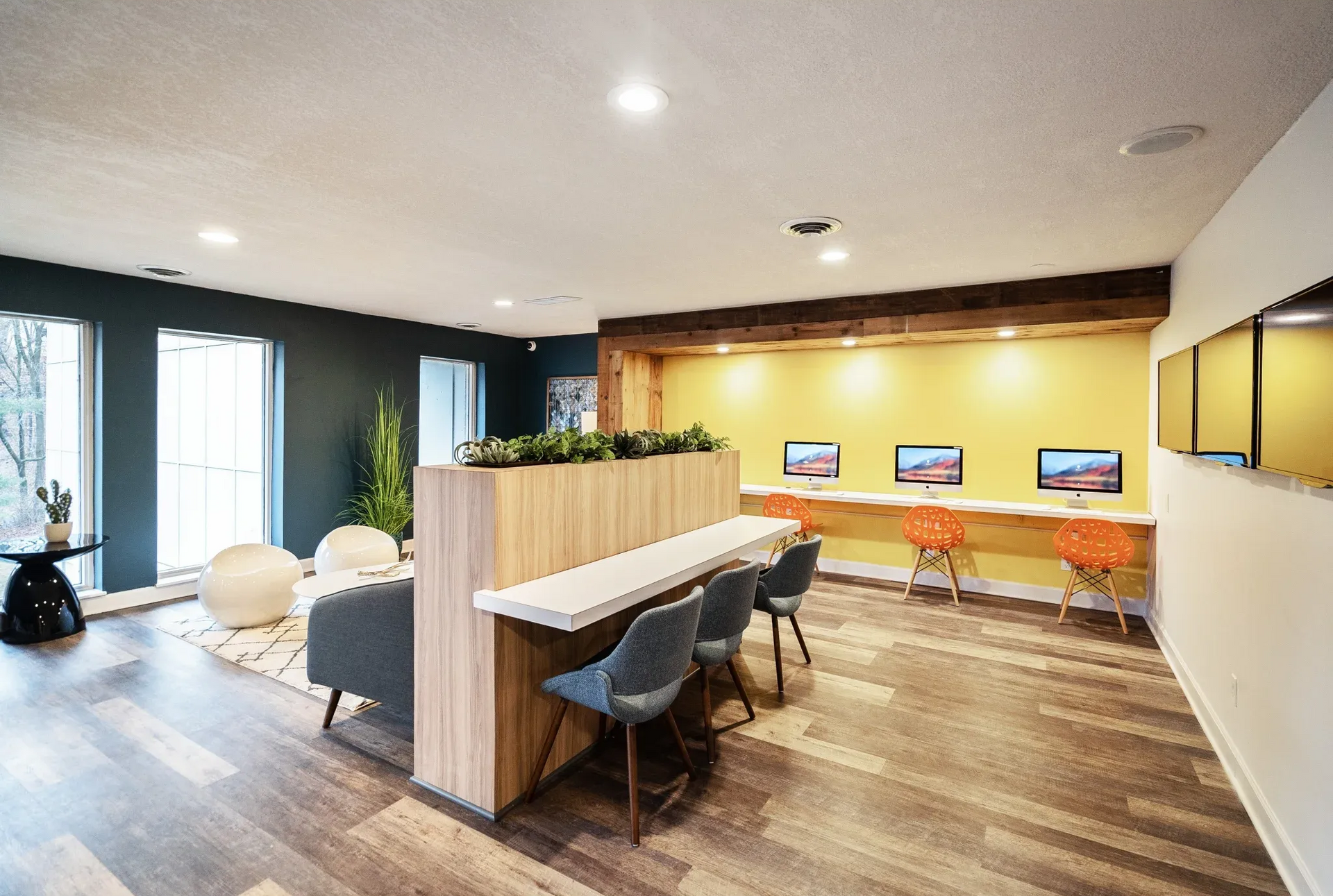 Community lounge with computer stations, seating, and plants.