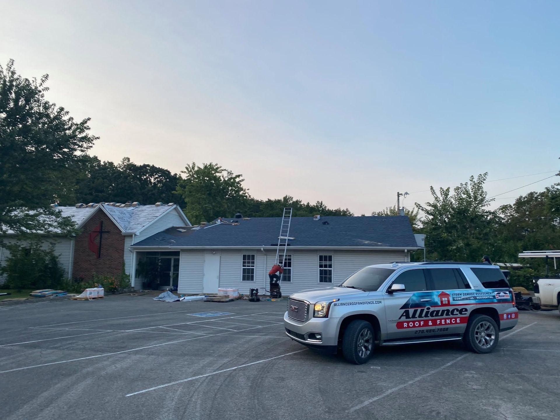 Silver AT&T service truck parked outside a small white building at dusk
