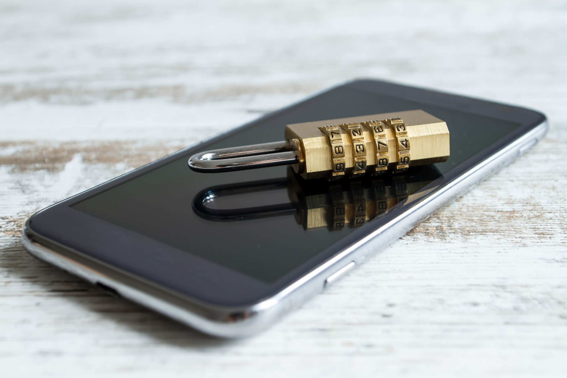 A cell phone with a padlock and a key on it.