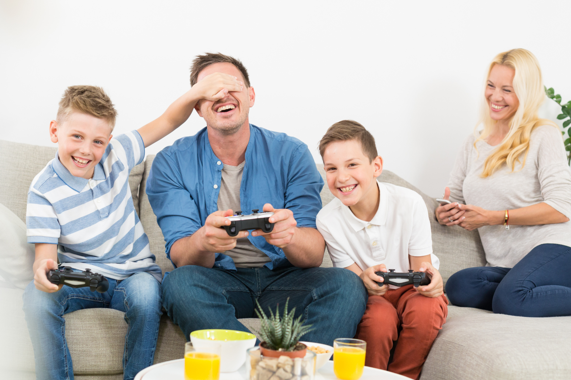 A family is sitting on a couch playing a video game.