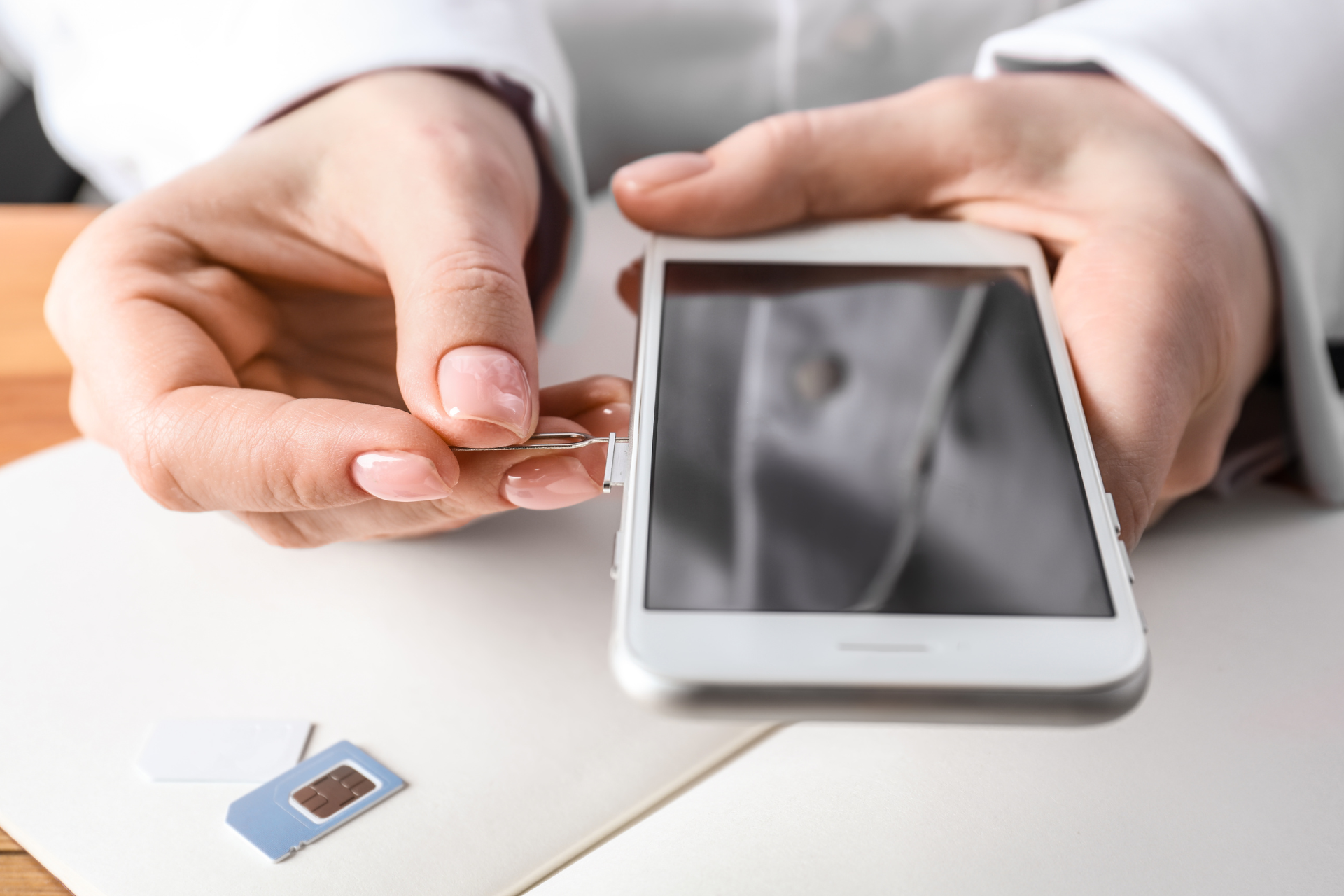 Person Opening iPhone SIM Card Slot