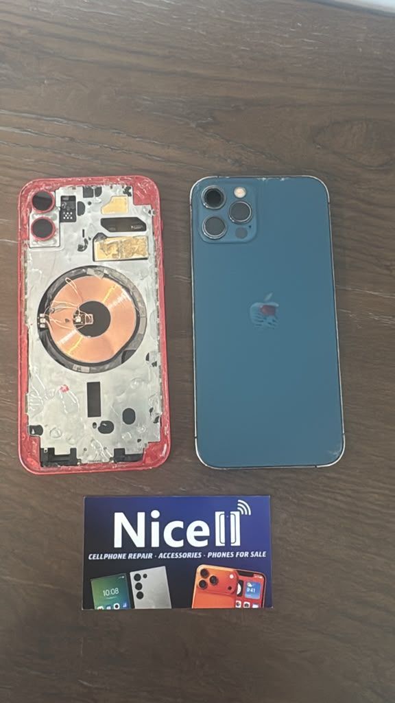 Two iPhones with protective cases on a wooden table at Nicell Cell Phone Repair in West Valley City,