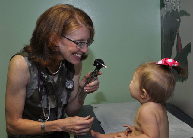 Doctor laughing when examining baby.
