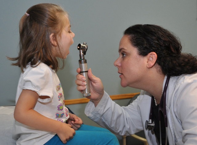 A doctor examining a young girl.