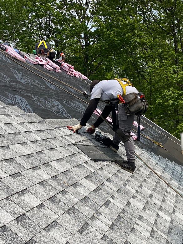 A man is working on the roof of a house.