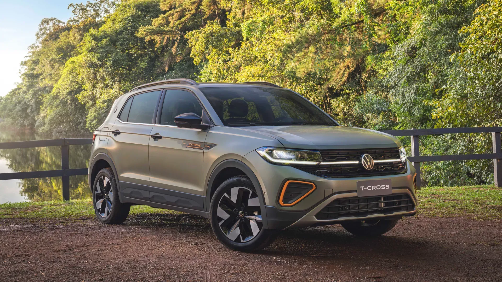 SUV Volkswagen T-Cross cinza estacionado em uma estrada de terra em um ambiente natural.