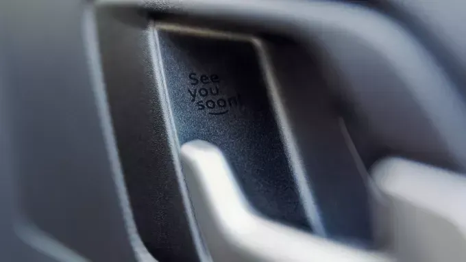 Close da maçaneta de uma porta de carro com a inscrição 