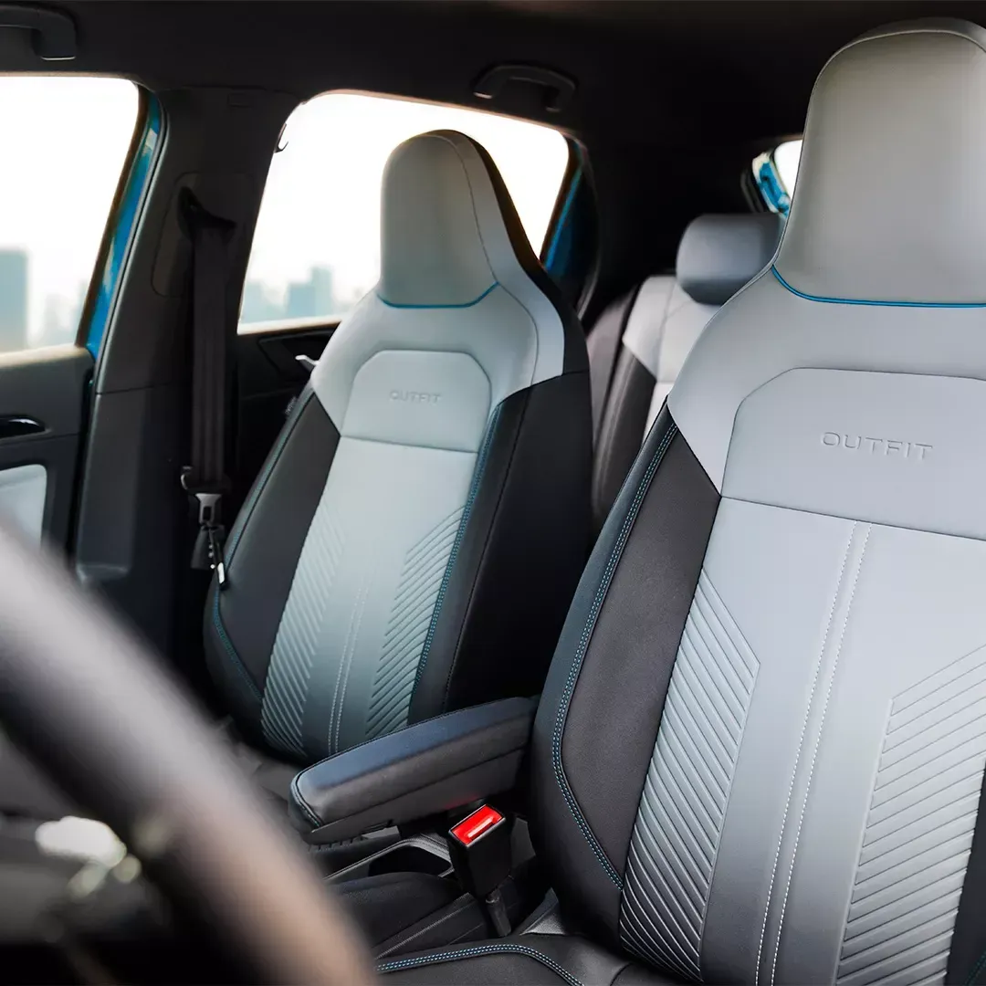 Interior do carro, bancos cinza e preto com detalhes em azul, volante à vista.