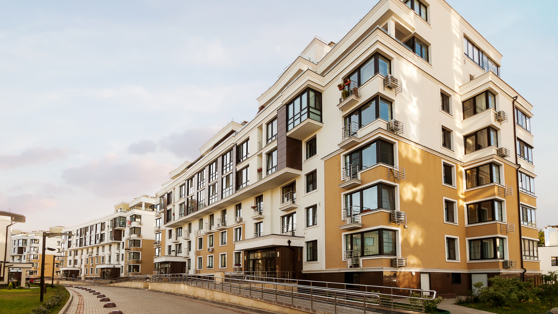 A large apartment building with a lot of windows in a residential area.