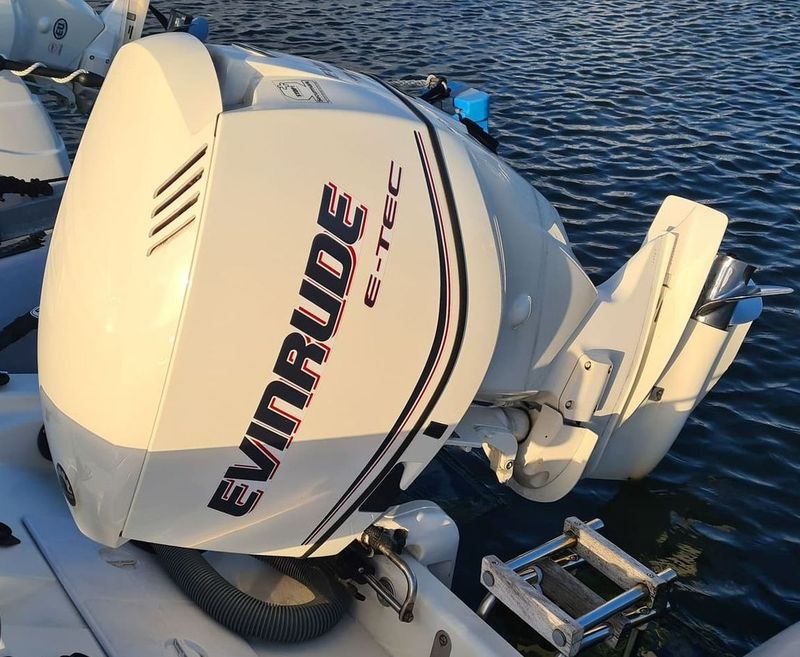 A white evinrude outboard motor is sitting in the water