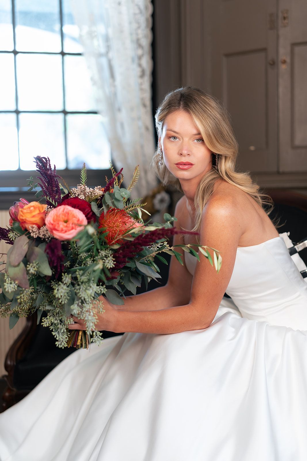 Bride in the Mansion's piano room, holding flowers