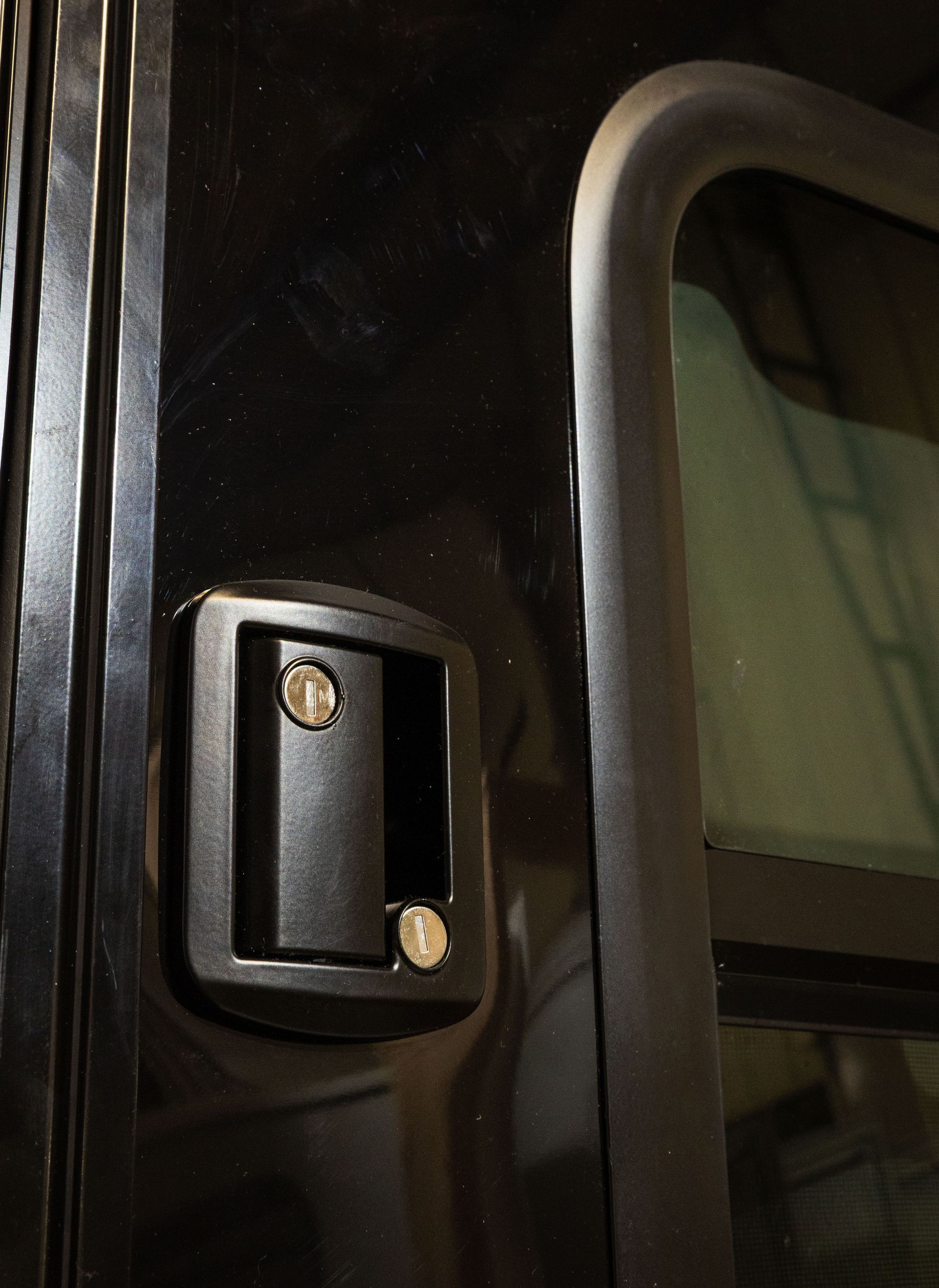 Tall white locker door with a black handle on a plain background