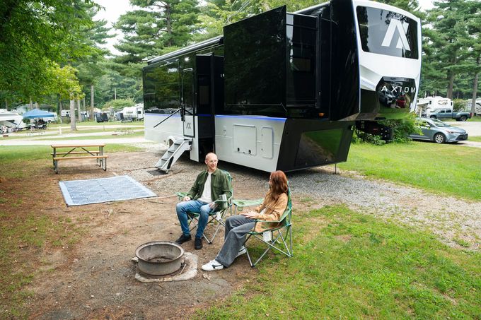 Open rear storage compartment of a black camper trailer with light wood interior.