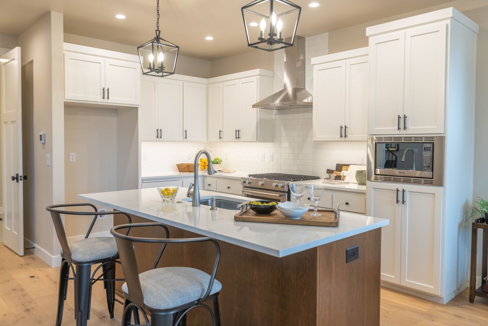 Bright modern kitchen with white cabinets, island, and stainless steel appliances