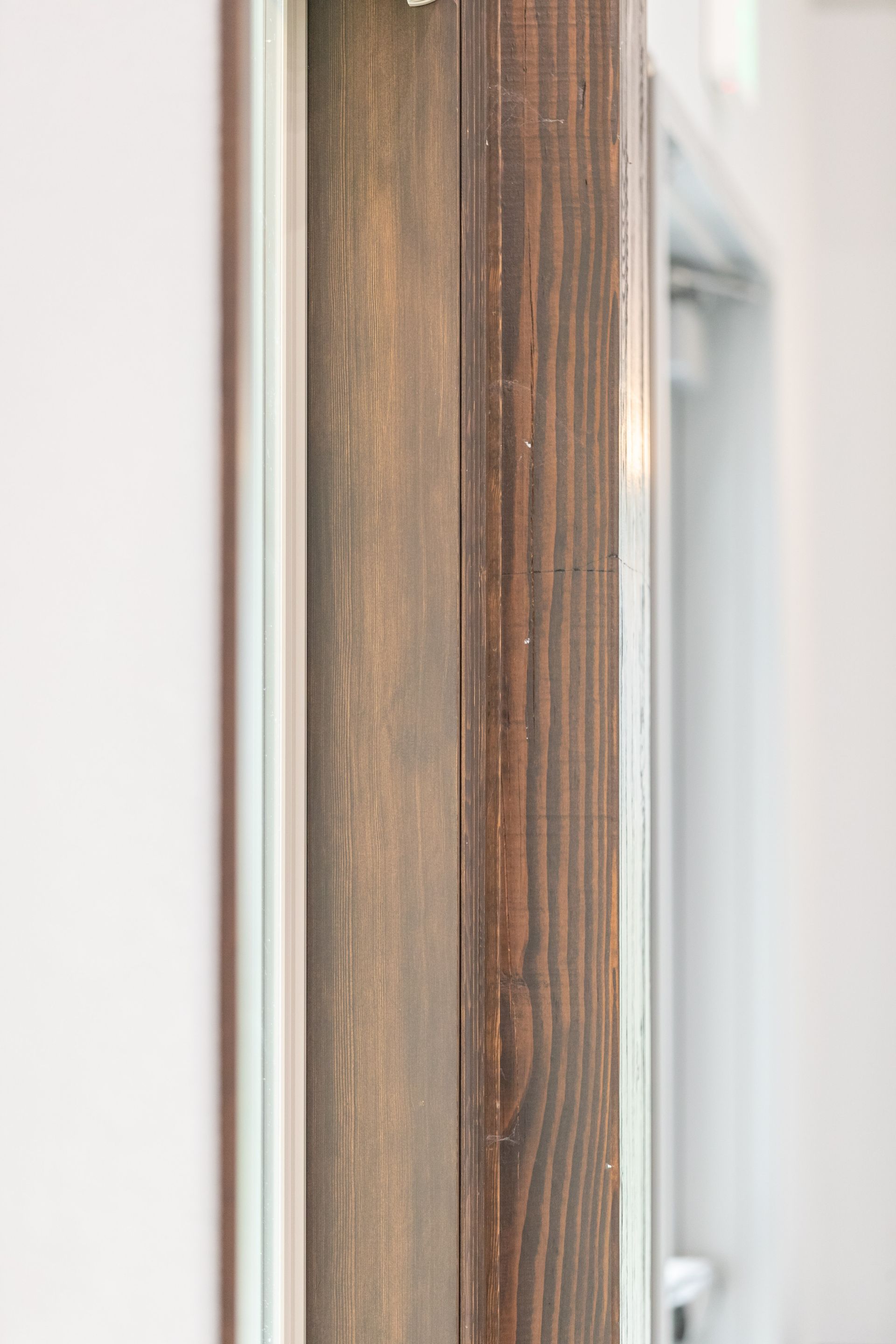 Close-up of a wooden door frame beside a frosted glass panel
