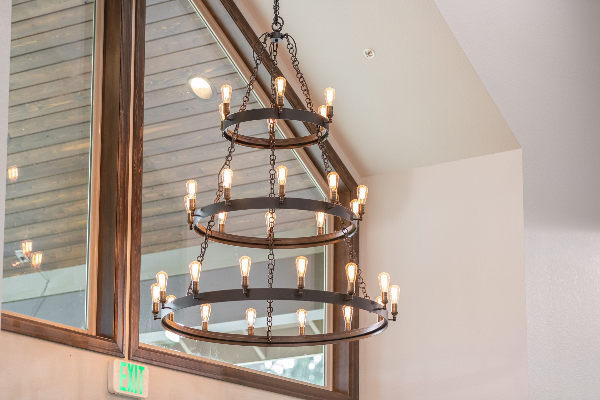 Modern chandelier with candle-style lights hanging in a bright interior atrium