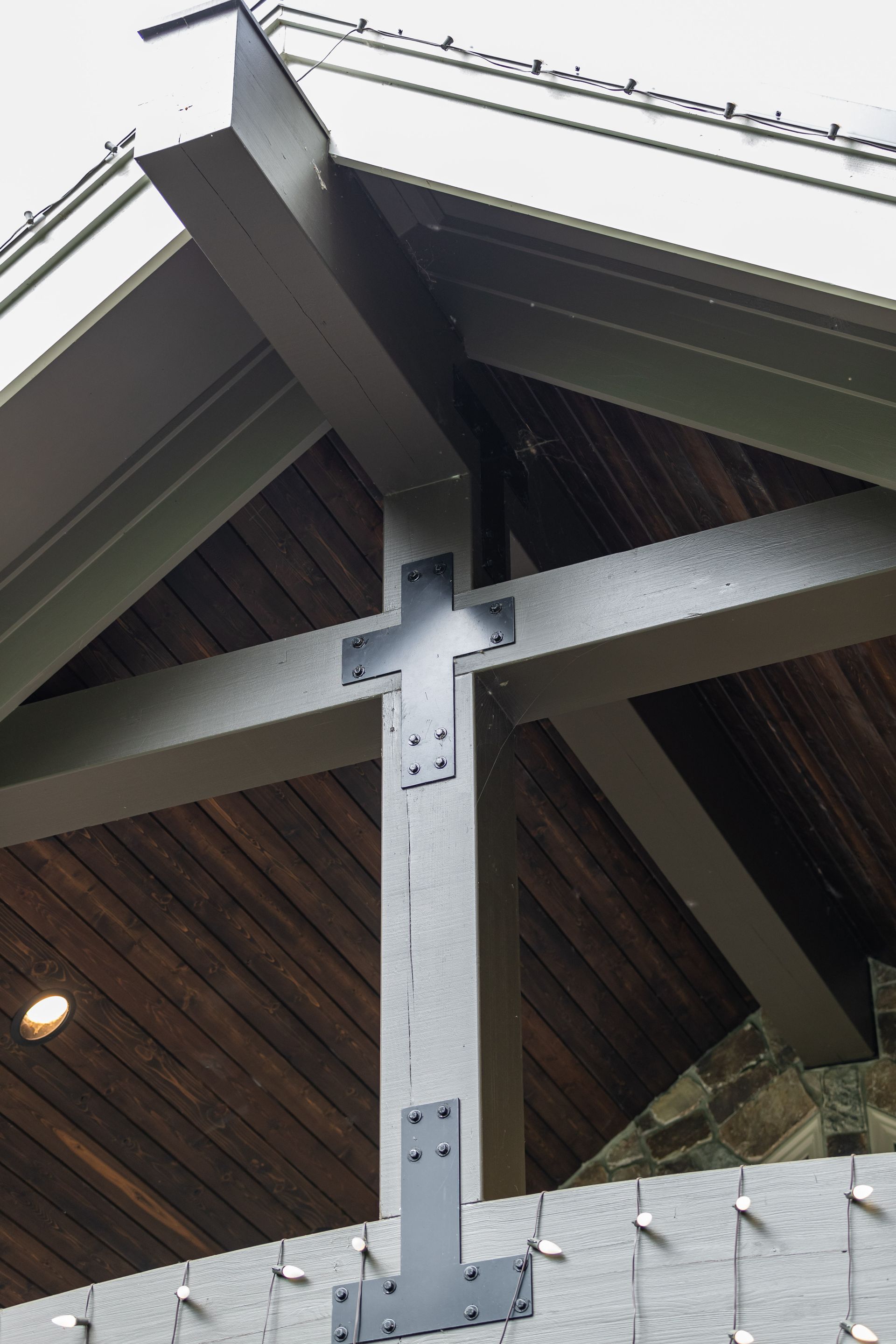 Close-up of a metal roof support beam and wooden gable under an overhang