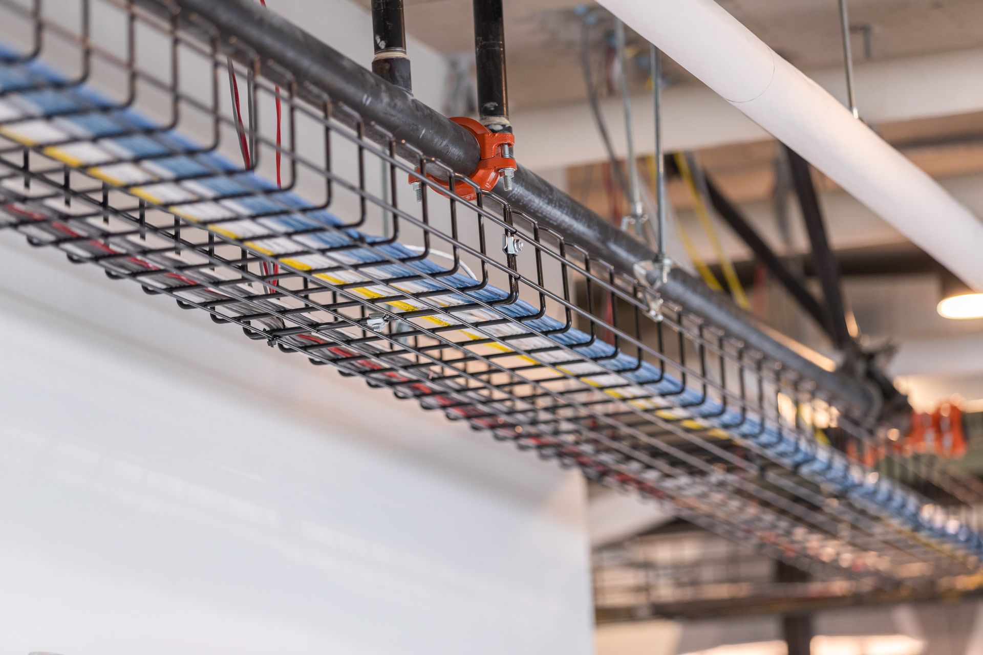 Suspended cable tray with bundled wires in an industrial ceiling space