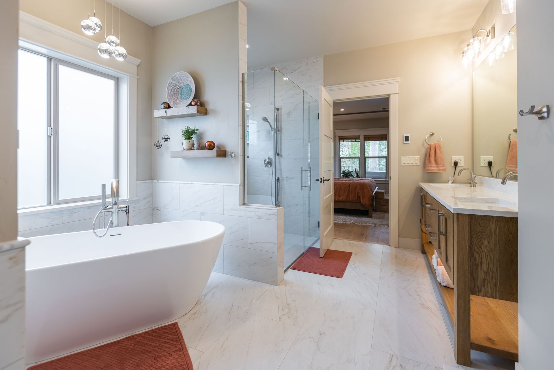 Bright modern bathroom with freestanding tub, glass shower, double vanity, and marble tile floor
