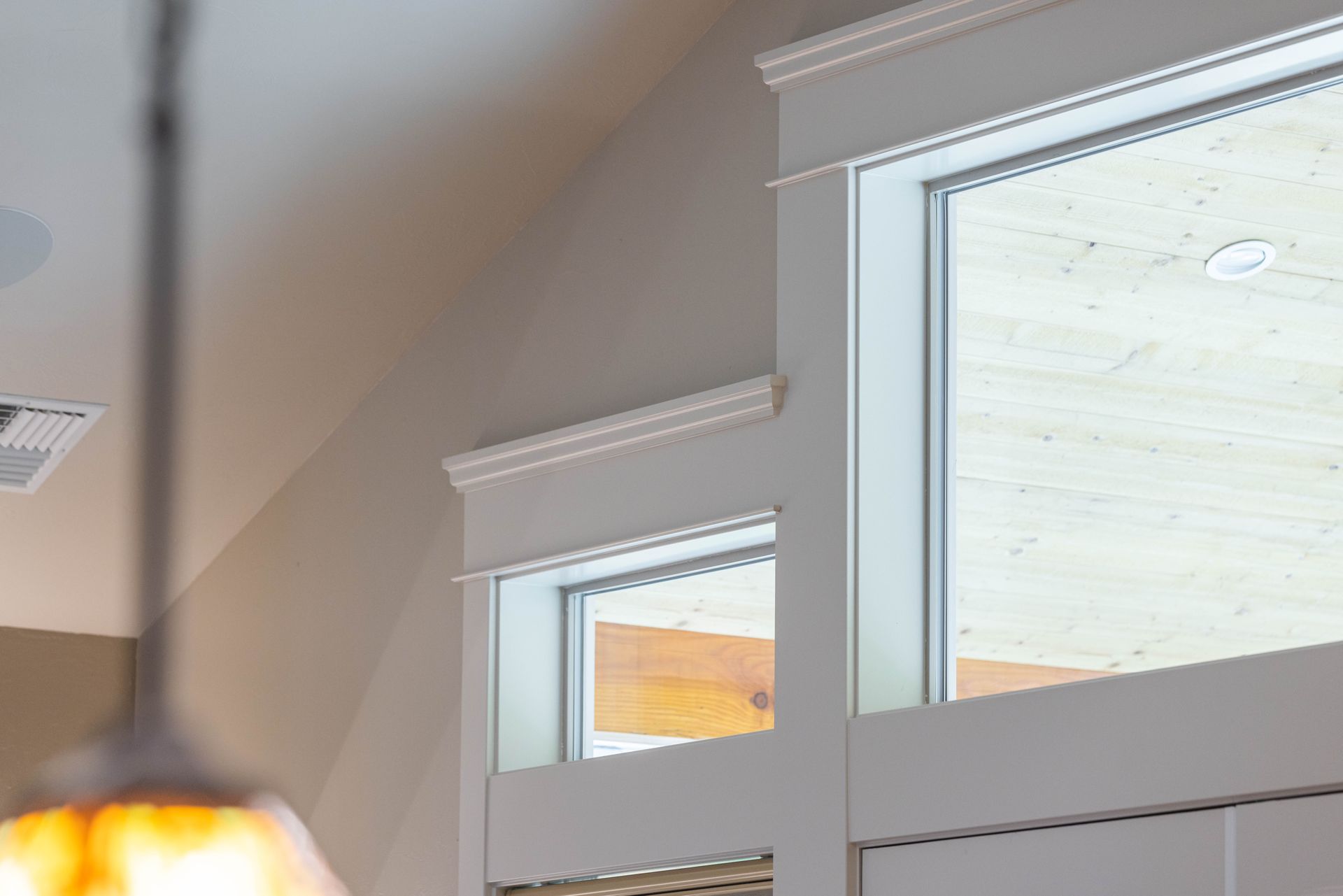 Modern interior with white-trimmed windows and a hanging pendant light