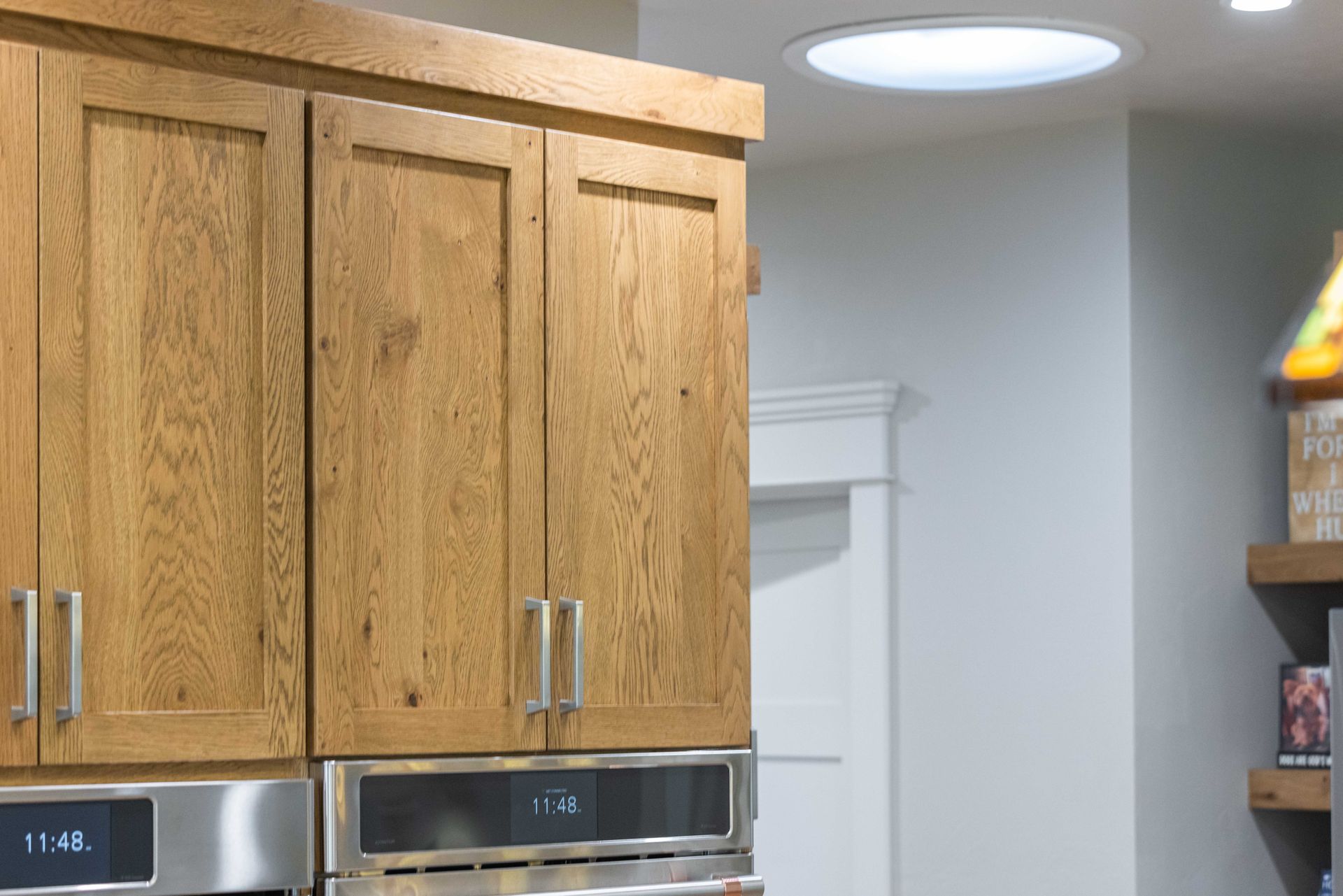 Kitchen cabinets and stainless-steel appliances beneath a round ceiling light in a modern kitchen
