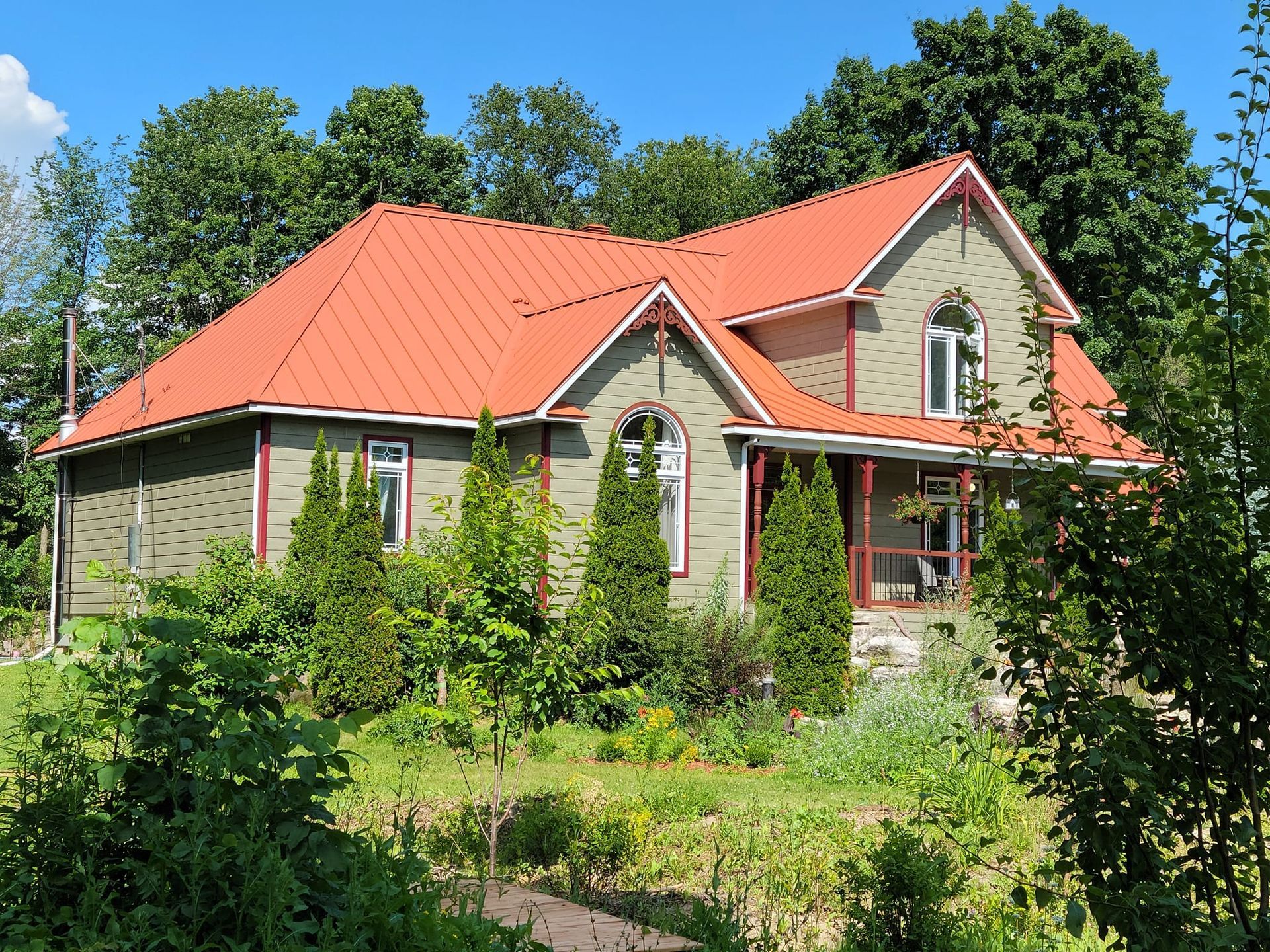 Une maison au toit rouge est entourée d'arbres