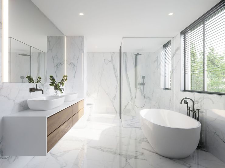 Bright modern bathroom with white marble walls, double vanity, glass shower, and freestanding tub. Bright modern bathroom with white marble walls, double vanity, glass shower, and freestanding tub.