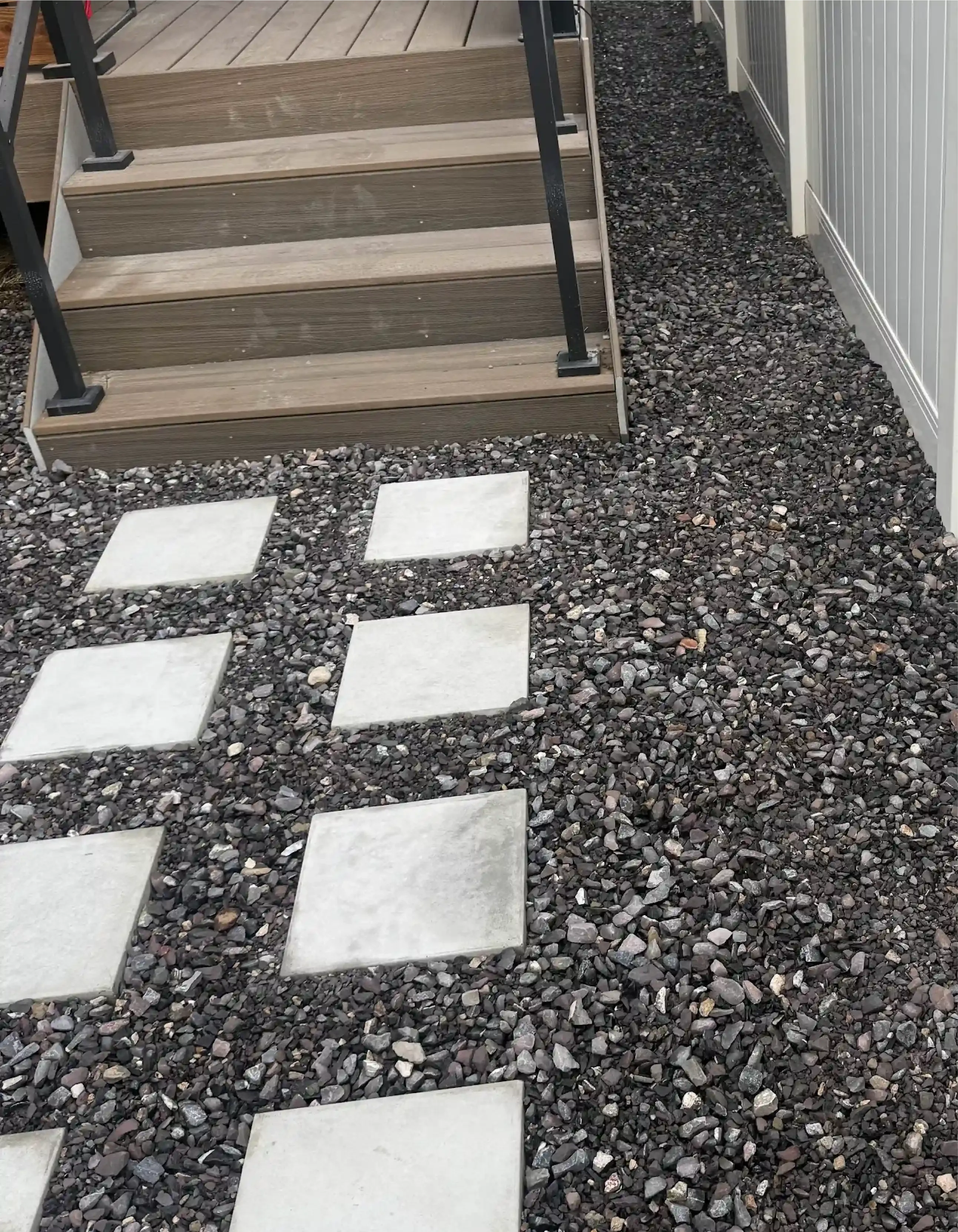 Steps leading up, with stepping stones through black gravel.