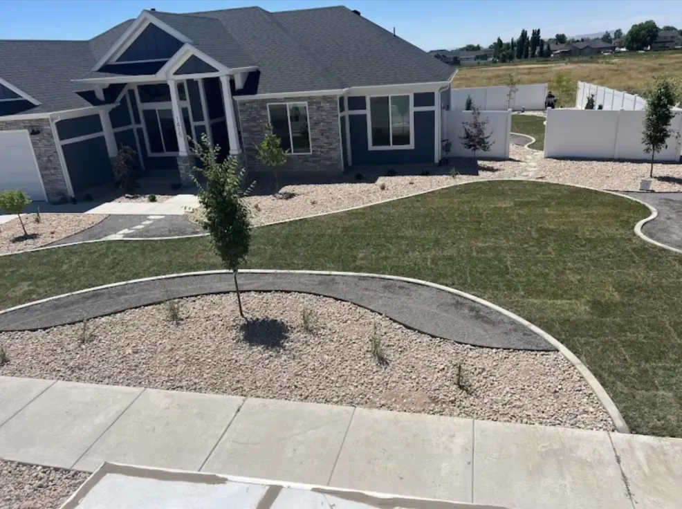 A house with a blue exterior and a landscaped yard with a curved path.