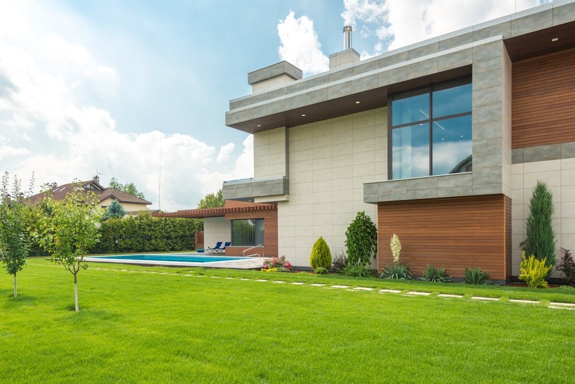 Modern house with pool and green lawn on a sunny day. Modern house with pool and green lawn on a sunny day.
