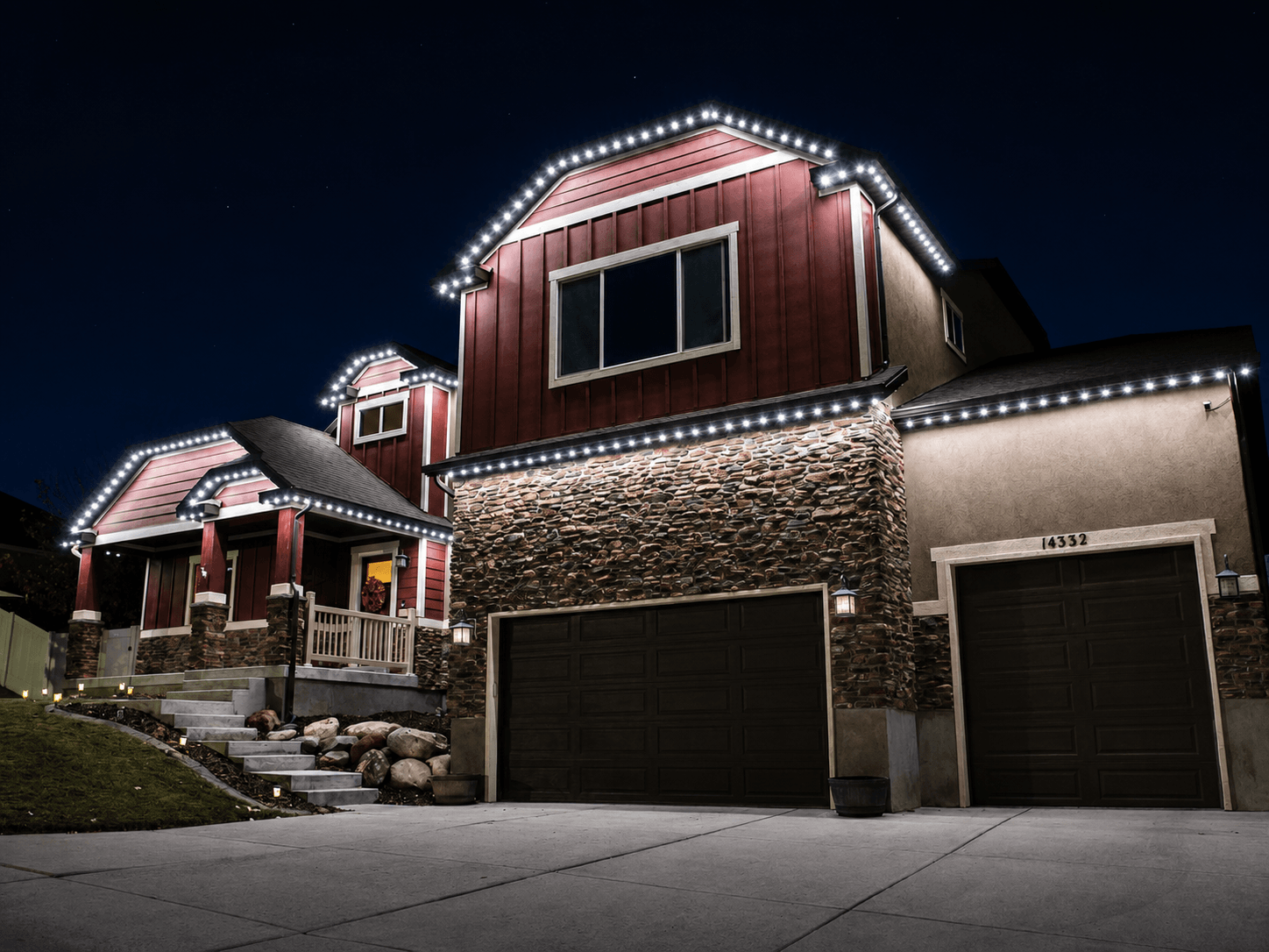 Permanent white LED roofline lighting on a two-story home at night.