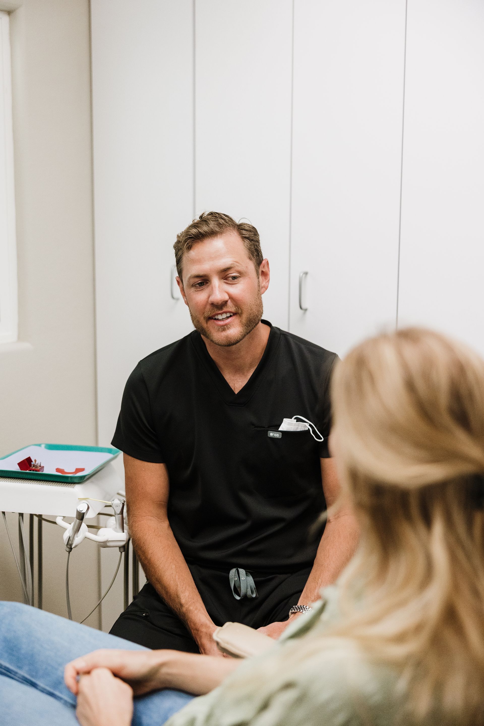 Aaron Miller talks with patient in dental office.