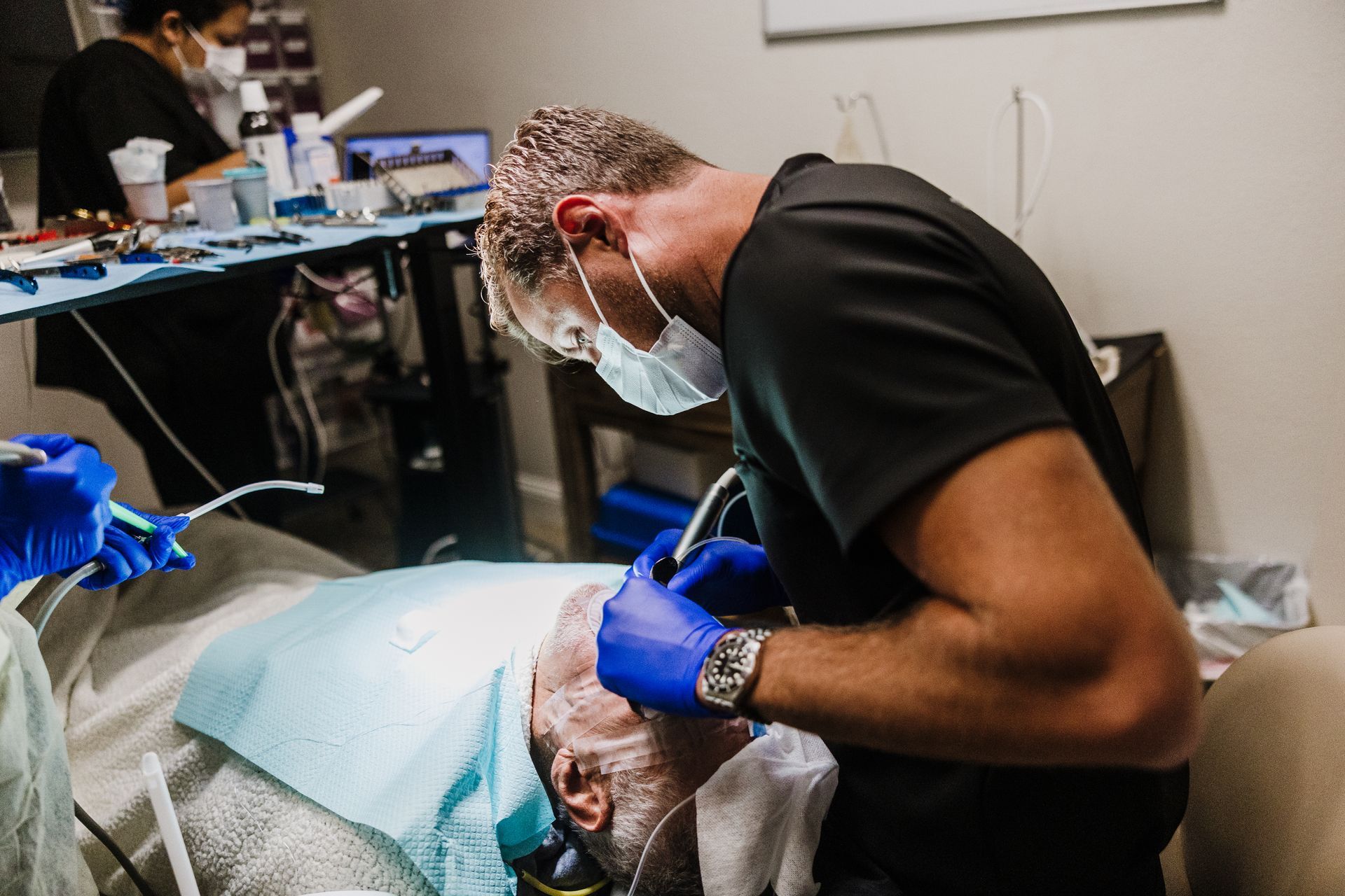 Dr. Aaron Miller wearing gloves and mask works on a patient during surgery.