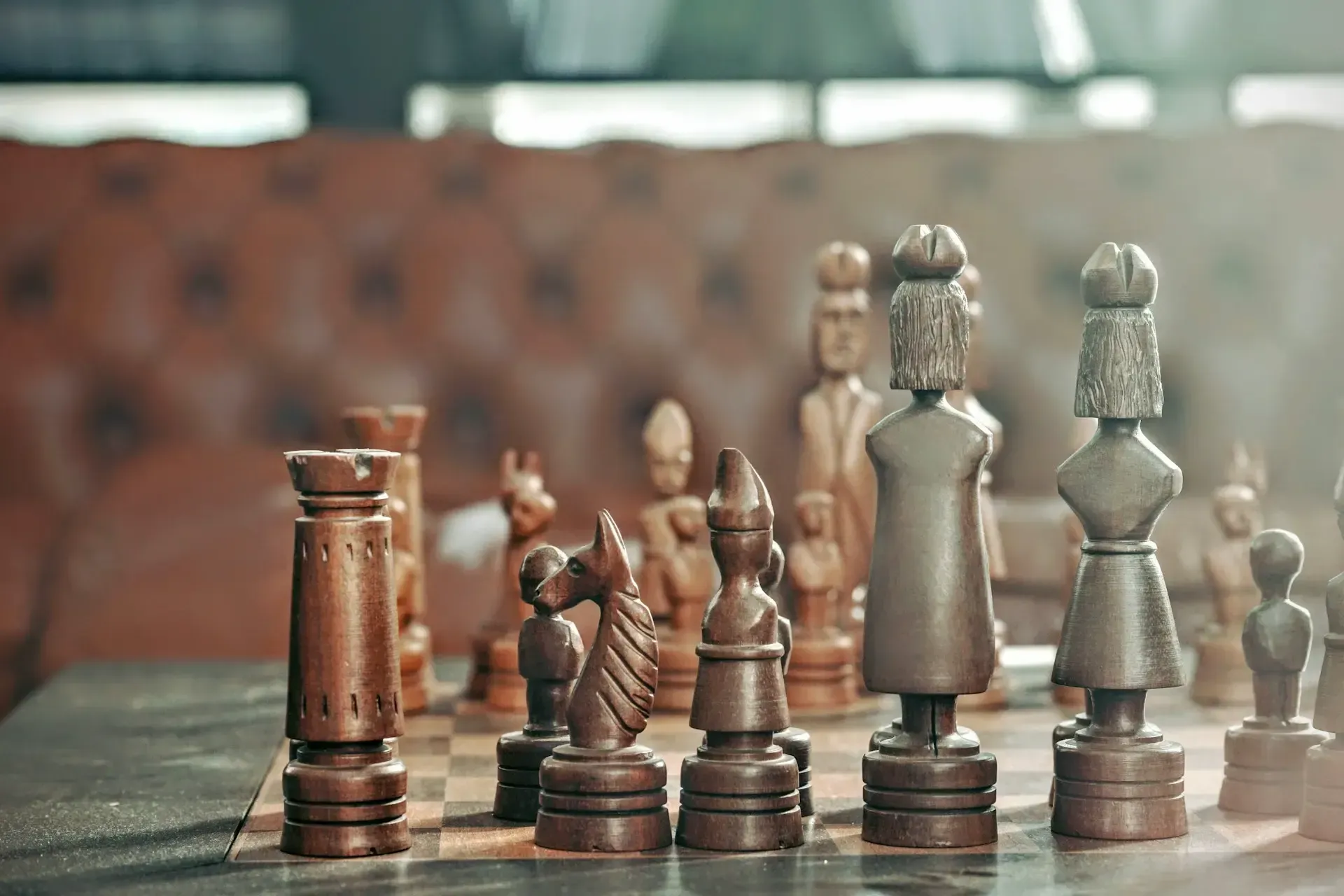 A wooden chess board with chess pieces on it.