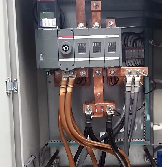 A close up of a electrical box with a lot of wires coming out of it.