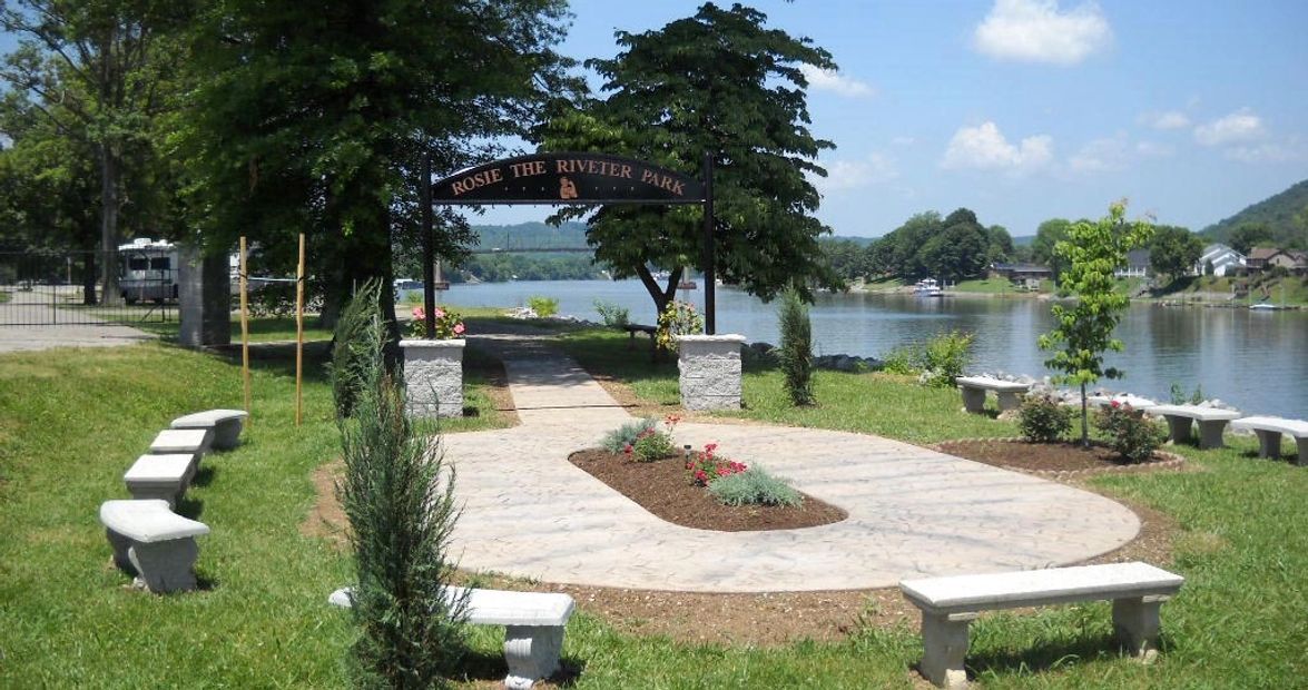 A circle of benches in a park with a lake in the background